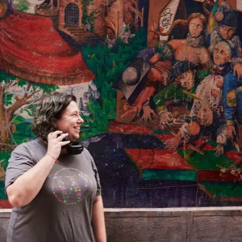 Marta Torre con camiseta gris con el isotipo de WordPress y unos auriculares de diadema negros mirando hacia un lado.